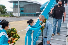 Chào đón 29 du khách quốc tế đầu tiên đến sân bay quốc tế Đà Nẵng sau đại dịch COVID-19. (Ảnh: TTXVN phát)