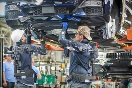 Công nhân làm việc trên dây chuyền sản xuất xe ô tô của Hãng BMW (Đức). Ảnh: DW/TTXVN)