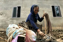 Người dân khối 1, thị trấn Mường Xén, Kỳ Sơn (Nghệ An), cố gắng tìm kiếm những tài sản còn sót lại sau trận lũ quét. (Ảnh: Văn Tý/TTXVN)