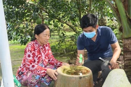 Nhân viên y tế giám sát mật độ lăng quăng, muỗi và tuyên truyền các biện pháp phòng, chống sốt xuất huyết cho hộ dân tại xã Hiếu Phụng, huyện Vũng Liêm, tỉnh Vĩnh Long. (Ảnh: Lê Thúy Hằng/TTXVN)
