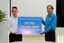 Lãnh đạo Liên đoàn Lao động tỉnh Nam Định trao tiền hỗ trợ người lao động bị thiệt hại trong vụ cháy. (Ảnh: Nguyễn Lành/TTXVN)