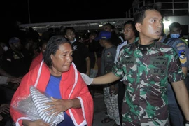Hành khách được lực lượng tìm kiếm cứu hộ Indonesia giải cứu trong vụ hoả hoạn trên tàu thuỷ KM Express Cantika 77 ở Kupang, tỉnh Đông Nusa Tenggara ngày 24/10/2022. (Ảnh: AFP/TTXVN)