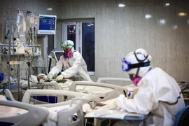 Nhân viên y tế điều trị cho bệnh nhân COVID-19 tại bệnh viện ở Iran. (Ảnh: IRNA/TTXVN)