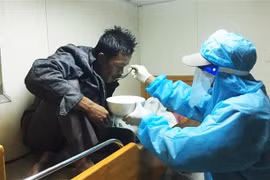 Thuyền viên tàu Kiểm ngư KN 464 chăm sóc sức khỏe cho ngư dân Benjamin Abdulla, sau khi ngư dân này được cứu vớt lên tàu. (Ảnh: TTXVN)