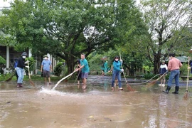 Người dân dọn bùn sau lũ ở khu vực Phong Nha-Kẻ Bàng của tỉnh Quảng Bình. (Ảnh: Đức Thọ/TTXVN)