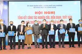 Phó Chủ tịch Ủy ban Nhân dân thành phố Hải Phòng Lê Khắc Nam tặng sách cho các đại biểu. (Ảnh: TTXVN)