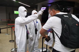 Kiểm tra thân nhiệt phòng lây nhiễm COVID-19 tại sân bay quốc tế Phnom Penh (Campuchia). (Ảnh: THX/TTXVN)