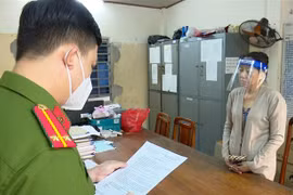 Nguyễn Thị Kim Hạnh (tức Mười Tường) nghe công an đọc quyết định khởi tố. (Ảnh: TTXVN)