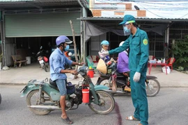 Lực lượng chức năng huyện Ba Tri (Bến Tre) thực hiện các biện pháp phòng dịch COVID-19, hồi tháng 7/2021. (Ảnh Công Trí/TTXVN)