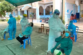 Lực lượng y tế xét nghiệm sàng lọc COVID-19 cho người dân thành phố Vĩnh Long. (Ảnh: Lê Thúy Hằng/TTXVN)
