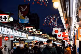 Người dân đeo khẩu trang phòng lây nhiễm COVID-19 tại Tokyo (Nhật Bản). (Ảnh: AFP/TTXVN)