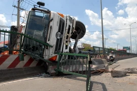 Xe tải lật nhào qua dải phân cách, hai thanh niên thoát chết