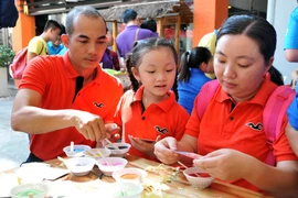 Các gia đình trẻ tham gia trò chơi vẽ tranh cát tại Ngày Gia đình Việt Nam 2015 tại Thành phố Hồ Chí Minh. (Ảnh: An Hiếu/TTXVN)