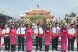 Các lãnh đạo tỉnh, địa phương và đại biểu cắt băng khánh thành Di tích khu mộ tập thể Liệt sỹ thuộc Sư đoàn 3 Sao vàng. (Ảnh: Viết Ý/TTXVN)