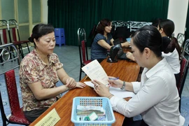 Một điểm chi trả lương hưu. (Ảnh: Minh Quyết/TTXVN)