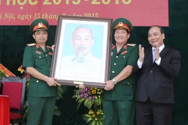 Phó Thủ tướng Nguyễn Xuân Phúc tặng quà lưu niệm cho Học viện Hậu cần. (Ảnh: Phương Hoa/TTXVN)