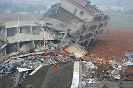 Lực lượng cứu hộ tìm kiếm người mất tích tại hiện trường vụ lở đất. (Nguồn: THX/TTXVN)