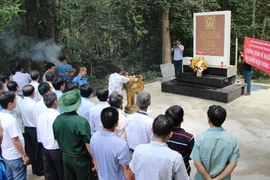 Các cựu chiến binh thắp hương tưởng niệm các anh hùng liệt sỹ Thông tấn xã Giải phóng. (Ảnh: Lê Đức Hoảnh/TTXVN)