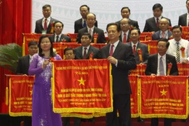 Thủ tướng Nguyễn Tấn Dũng tặng cờ thi đua của Chính phủ cho các huyện đã có thành tích xuất sắc trong phong trào xây dựng Nông thôn mới. (Ảnh: Vũ Sinh/TTXVN)