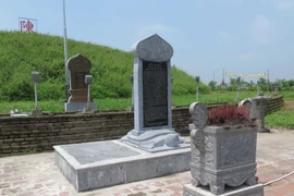 Trước mỗi gò mộ vẫn còn 2 tấm bia đá và bia đá ốp đồng tồn tại (chụp chiều ngày 16/5). (Ảnh: Xuân Tiến-Hải An/Vietnam+)