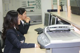 Nhân viên Bộ phận phận kiểm tra chất lượng xe cơ giới làm việc tại Cảng SPCT. (Ảnh: Xuân Tình/Vietnam+)