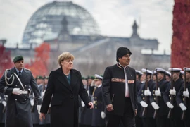 Thủ tướng Đức Angela Merkel (trái) và Tổng thống Bolivia Evo Morales (phải) duyệt đội danh dự tại lễ đón. (Nguồn: AFP/TTXVN)