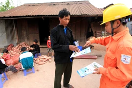Nhân viên điện lực hướng dẫn người dân Sín Thầu (Điện Biên) sử dụng điện an toàn, tiết kiệm. (Ảnh: Ngọc Hà/TTXVN)