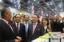 Phó Thủ tướng Malaysia Muhyiddin Yassin (đi đầu) và Tổng Thư ký ASEAN Lê Lương Minh (thứ hai) thăm gian hàng của Việt Nam. (Ảnh: Kim Dung-Chí Giáp/Vietnam+)