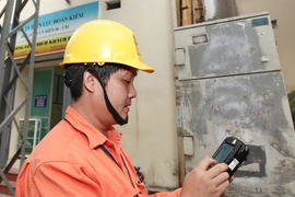 Công nhân Công ty Điện lực Hoàn Kiếm áp dụng ghi chỉ số côngtơ bằng hệ thống đo xa. (Ảnh: Ngọc Hà/TTXVN)