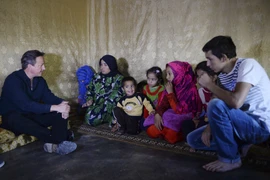 :Thủ tướng Anh David Cameron (trái) thăm khu định cư cho người tị nạn ở thung lũng Bekaa, Liban ngày 14/9. (Nguồn: AFP/TTXVN)