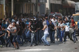 Người Palestine trong cuộc xung đột với cảnh sát Israel tại thành phố Ramallah, Bờ Tây ngày 6/10. (Nguồn: THX/TTXVN)