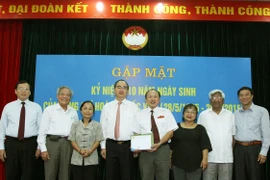 Chủ tịch Ủy ban Trung ương Mặt trận Tổ quốc Việt Nam Nguyễn Thiện Nhân và các đại biểu chụp ảnh chung với thân nhân gia đình ông Hoàng Quốc Việt. (Ảnh: Nguyễn Dân/TTXVN)