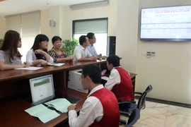 Nhà đầu tư theo dõi phiên đấu giá qua hệ thống điện tử tại Sở Giao dịch Chứng khoán Hà Nội (HNX). (Ảnh: Tuấn Anh/TTXVN)