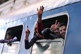 Người di cư vui mừng sau khi được lên tàu tới biên giới Hungary-Áo ngày 5/9. (Nguồn: AFP/TTXVN)