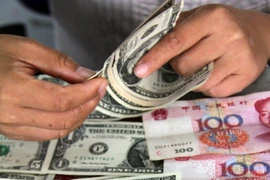 Kiểm đồng USD và đồng nhân dân tệ tại ngân hàng ở Sơn Đông. (Nguồn: THX/TTXVN)