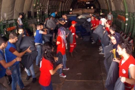 Nhân viên Chữ thập Đỏ Syria chuyển hàng cứu trợ từ máy bay của Nga tại sân bay quốc tế Martyr Bassil al-Assad thành phố Latakia. (Nguồn: AFP/TTXVN)