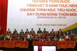 Thủ tướng Chính phủ Nguyễn Tấn Dũng tặng cờ thi đua của Chính phủ cho các huyện đã có thành tích xuất sắc trong phong trào xây dựng Nông thôn mới. (Ảnh: Vũ Sinh/TTXVN)