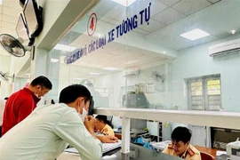 Người dân nộp hồ sơ tại Đội Đăng ký, Quản lý Phương tiện Giao thông Cơ giới Đường bộ. (Ảnh: Thành Chung/TTXVN)