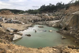 Khu vực mỏ có nhiều hố sâu sau khi lớp đất, đá bị đào lên. (Ảnh: TTXVN phát)