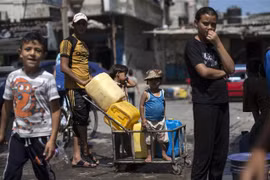Trẻ em Palestine xếp hàng lấy nước sinh hoạt tại thành phố Gaza. (Ảnh: AFP/TTXVN)