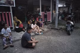 Người dân chạy ra khỏi nhà do lo ngại những dư chấn sau trận động đất mạnh 7,3 độ tại Labuha, Indonesia, ngày 14/7. (Ảnh: AFP/TTXVN)