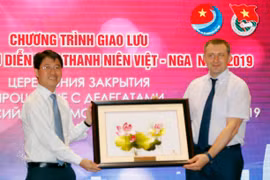 Đại diện Thành Đoàn Thanh niên Cộng sản Hồ Chí Minh tặng quà lưu niệm cho ông Alexander Bugaev (Ảnh: Hoàng Hải/TTXVN)