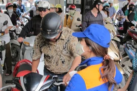 Nhân viên Petrolimex đang bán xăng cho khách hàng. (Ảnh: Đức Duy/Vietnam+)