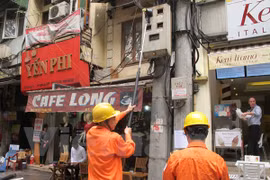 Nhân viên EVN Hà Nội ghi chỉ số côngtơ trên địa bàn. (Ảnh: Đức Duy/Vietnam+)