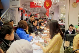 Khách hàng đang giao dịch vàng miếng. (Ảnh: Đức Duy/Vietnam+)