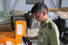 Cán bộ Đội Quản lý thị trường số 17 đang kiểm tra hàng hóa. (Ảnh: Đức Duy/Vietnam+)