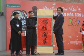 Lãnh đạo Bảo tàng Dân tộc học Việt Nam chụp ảnh cùng các nghệ nhân. (Ảnh: Quỳnh Chi/Vietnam+)