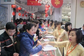 Khách hàng đang giao dịch vàng miếng. (Ảnh: Đức Duy/Vietnam+)