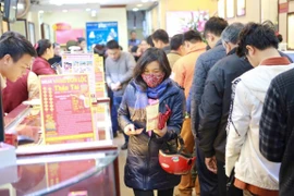 Khách hàng giao dịch vàng miếng trong ngày Thần Tài. (Ảnh: PV/Vietnam+)