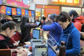 Khách hàng đang giao dịch vàng miếng. (Ảnh: Đức Duy/Vietnam+)